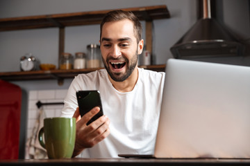 Wall Mural - Happy young man using laptop computer