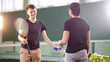 © KONSTANTIN SHISHKIN - Training on the tennis court. Young men talking