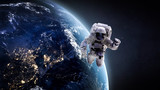 Nightly Earth and astronaut in the outer space. Abstract wallpaper. City lights on planet. Spaceman. Elements of this image furnished by NASA