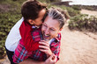 © Snapwire - Smiling father carrying his son piggyback outdoor