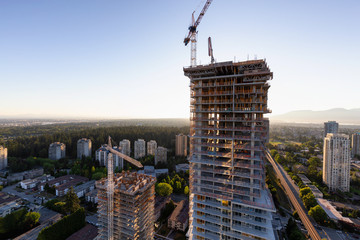 Aerial view of a residential building construction site during a vibrant summer sunset. Taken in Burnaby, Vancouver, BC, Canada.