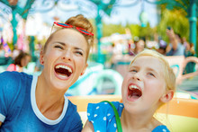 Mother And Child Travellers In Amusement Park Enjoying Ride