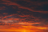 Fototapeta Na sufit - Fiery red blood vampire dawn. Amazing warm dramatic fire cloudy sky. Vivid orange sunlight. Atmospheric background of sunrise in overcast weather. Hard cloudiness. Storm clouds warning. Copy space.