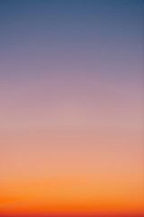 Wall Mural - predawn clear sky with orange horizon and violet atmosphere. smooth orange violet gradient of dawn s