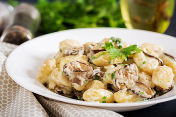 Wall Mural - Gnocchi with a mushroom cream sauce and parsley  in bowl on a dark background