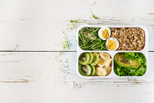 Lunch box  with boiled eggs, oatmeal, avocado, micro greens and fruits.  Healthy fitness food. Take away. Lunchbox. Top view