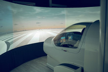 Side View Of Male Trainee Flying Flight Simulator Seen Through Windshield