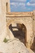 A footbridge that links one side of Alicante’s fort to the other during mid morning with the sun casting long shadows inside the moat of this ancient fort in southern Spain.