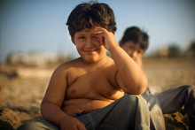 Portrait Of A Small Topless Boy On The Beach.