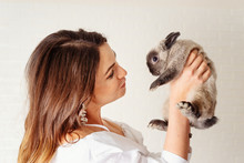 Beautiful Young Woman Holds A Cute And Fluffy Gray Rabbit