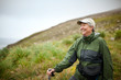 © Erickson Stock - Woman smiles as she stops to admire the scenery on a hike.