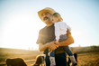 © Erickson Stock - Smiling cowboy carrying his daughter on ranch