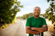 © Erickson Stock - Portrait of smiling mature man standing on road