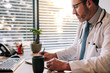 © Jacob Lund - Doctor at office making notes in his diary