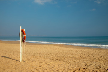 Wall Mural - Life buoy on a pole on a sandy beach