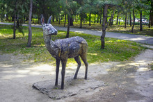 Old Shabby Sculpture Of Roe Deer In A City Park.