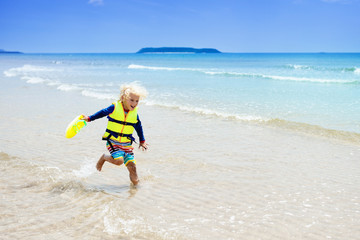 Wall Mural - Child on tropical beach. Sea vacation with kids.