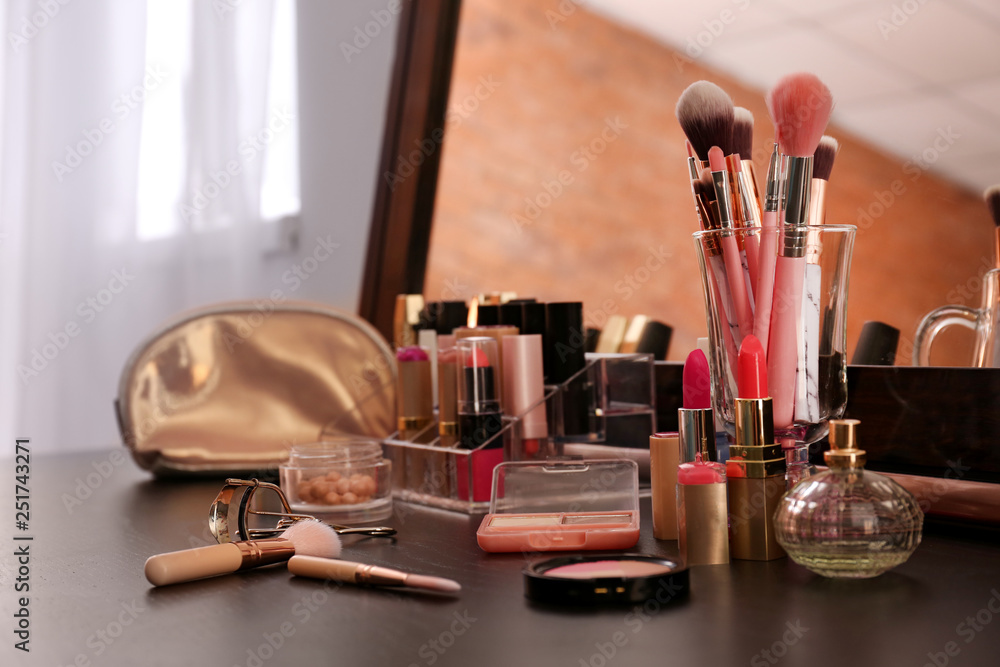 Set of makeup brushes and cosmetics on table