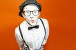 © rh2010 - Portrait of an actor as a pantomime with white facial makeup showing expressive emotions on the orange background in the studio