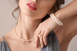 canvas print picture - Young woman with beautiful pearl jewelry on light background, closeup