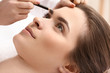 © Pixel-Shot - Young woman undergoing eyebrow correction procedure in beauty salon