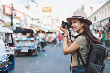 Wall Mural - Asian woman tourist backpacker travel and taking photo in Khao San road, Bangkok, Thailand