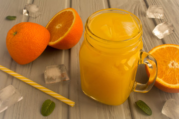 Wall Mural - Orange juice with ice in the glass on the grey  wooden background