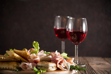 Canvas Print - Italian aperitif - aperitivo: Crescentina modenese or tigelle, Gnocco fritto or Crescentina, salad, prosciutto, and wine. All products are made in Italy, Emilia-Romagna.