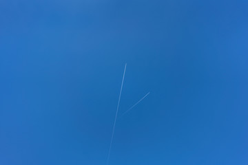 Blue sky with two airplanes at high altitude.