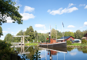 Historic ship by bridge in Hjalmaren canal, Arboga, Sweden