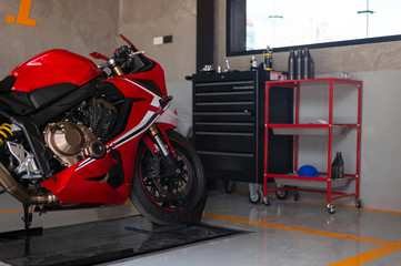 closeup sport motorcycle in repair station and body shop with soft-focus and over light in the background