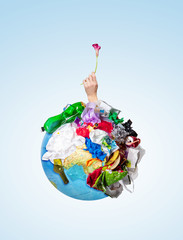 An earth globe covered with trash and male hand with a withering flower over white background, the concept of ecology problem and World Environment Day. Photo with message for social advertising