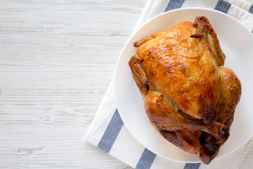 Wall Mural - Homemade tasty rotisserie chicken on white plate, top view. Flat lay, overhead, from above. Copy space.