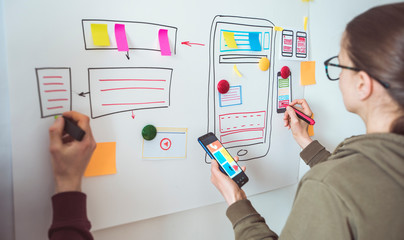 Wall Mural - designer develops applications for mobile phones. people creates a prototype user experience interfa