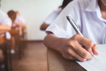 Wall Mural - Close up to School student is taking exam and writing answer in classroom for education test concept