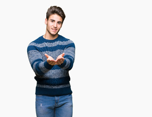 Young handsome man over isolated background Smiling with hands palms together receiving or giving gesture. Hold and protection