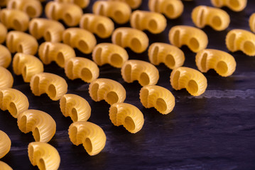 yellow raw Italian pasta food on black background