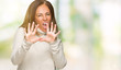 © Krakenimages.com - Beautiful middle age adult woman wearing winter sweater over isolated background afraid and terrified with fear expression stop gesture with hands, shouting in shock. Panic concept.