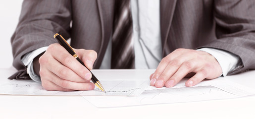 closeup.serious businessman signing documents ,sitting behind a