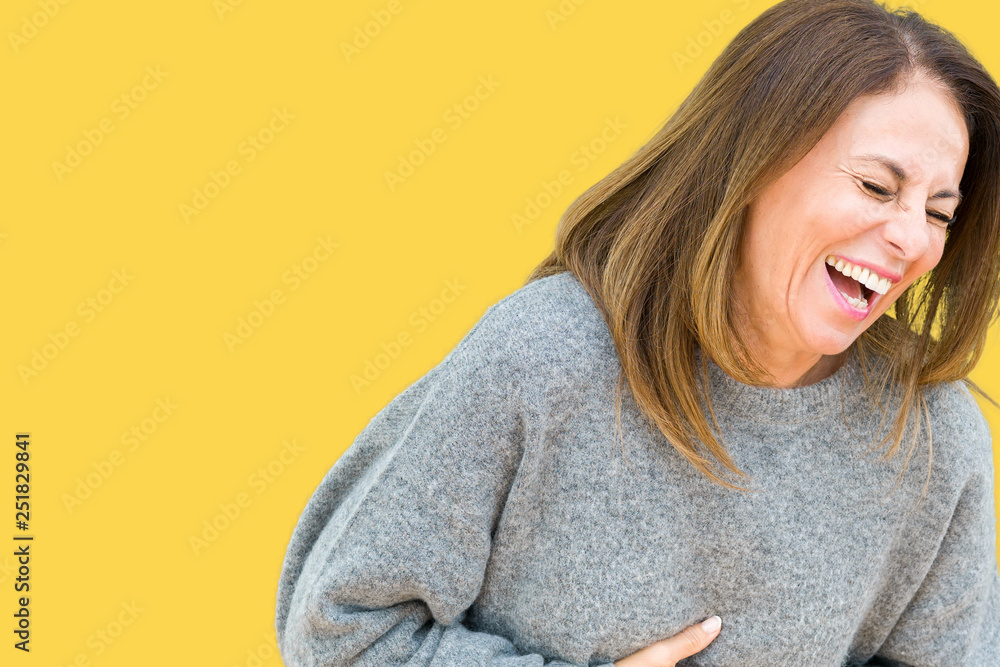Beautiful middle age woman wearing winter sweater over isolated background Smiling and laughing hard out loud because funny crazy joke. Happy expression. - obrazy, fototapety, plakaty 