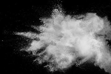 Wall Mural - White powder explosion isolated on black background. White dust particles splash.Color Holi Festival.