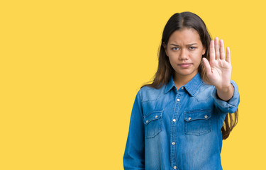 Canvas Print - Young beautiful brunette woman wearing blue denim shirt over isolated background doing stop sing with palm of the hand. Warning expression with negative and serious gesture on the face.