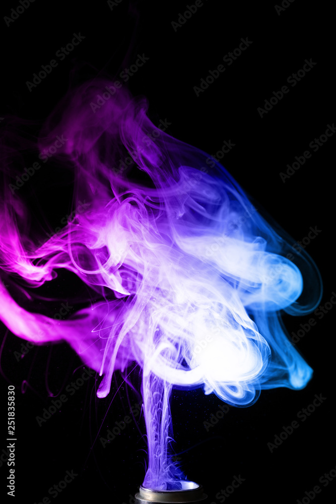 coloured vape smoke jars of liquids for vape in multi-colored smoke Stock Photo main image 1