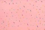 Fototapeta Uliczki - trendy pattern of colorful sprinkles for background of design banner, poster, flyer, card, postcard, cover, brochure over pink