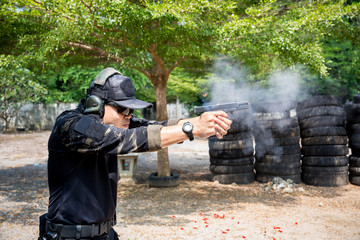 soldier shooting gun to target with bullet cartridge in the air. Mature man aiming with gun at combat training.