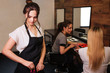© estradaanton - Beautiful woman hairdresser with black apron taking hair professional clip before hairstyling on salon background. Beauty and people concept