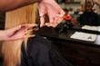 © estradaanton - Close up of hairdressers hand cutting blonde hair. Doing new haircut in beauty salon