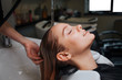 © estradaanton - Side view of beautiful young woman with closed eyes smiling while hairdresser rising hair after shampoo. Hair spa in beauty salon