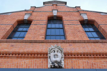 A building facade with brick wall .  Brick wall with windows and mask