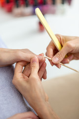 Wall Mural - Professional manicurist cleaning cuticle from behind a nail